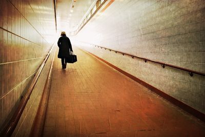 Rear view of a woman walking in subway