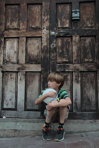 Full length of boy sitting outdoors