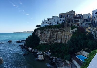 Scenic view of sea by cliff against sky