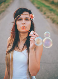 Portrait of beautiful young woman blowing bubbles