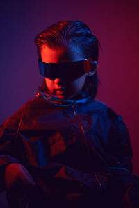 Portrait cyberpunk boy child in vr glasses in blue and red tones. game, virtual reality