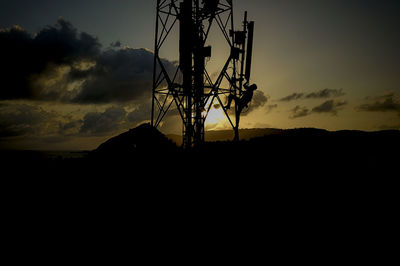 Low angle view of silhouette electricity pylon against sky during sunset