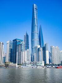 Modern buildings in city against clear blue sky