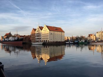 Sailboats in river against buildings in city