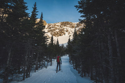 People walking on snow covered land against sky