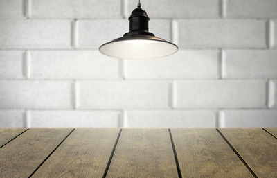 Close-up of illuminated light bulb against wall