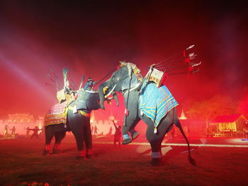 Men riding elephants during war at night