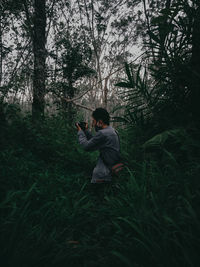 Man standing on field in forest