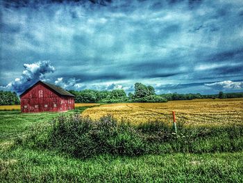 Scenic view of grassy field against cloudy sky