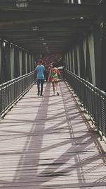 Rear view of people walking on road