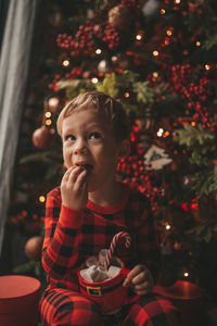 Portrait of girl blowing christmas tree at night