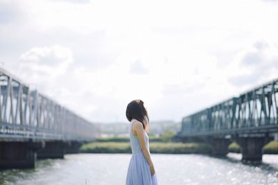 Rear view of woman on bridge against sky