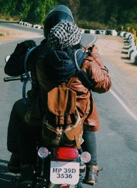 Rear view of man photographing on street