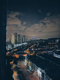 High angle view of illuminated buildings against sky at night