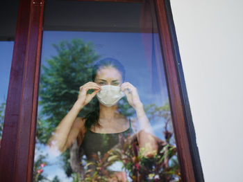 Portrait of man drinking water from glass window