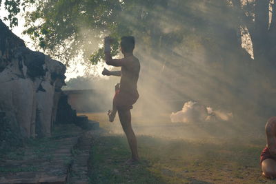 Side view of shirtless man exercising on land