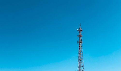 Low angle view of communications tower against clear blue sky