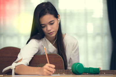 Portrait of a young woman sitting on table