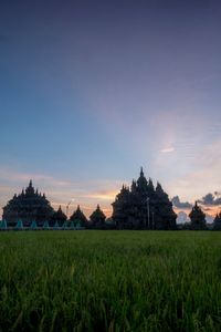 Temple on field against sky during sunset