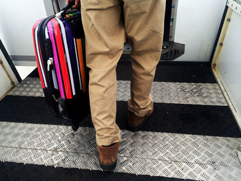 Low section of man carrying luggage in airplane