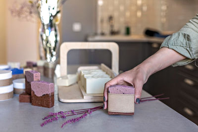 A soap-maker girl holds a piece of freshly brewed handmade soap in her hands.small business