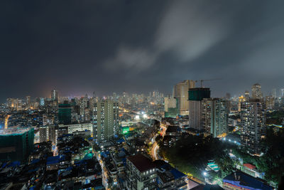 High angle view of illuminated buildings against sky at night