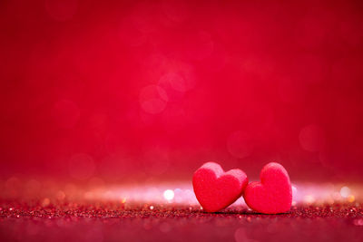 Close-up of heart shapes against glittering background