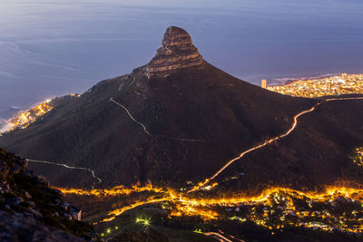 High angle shot of illuminated town against mountains