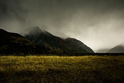 Scenic view of land and mountains against sky