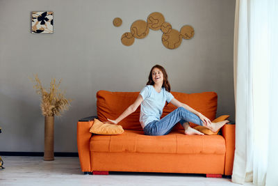 Portrait of woman sitting on sofa at home