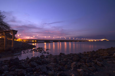 Scenic view of illuminated city against sky at sunset