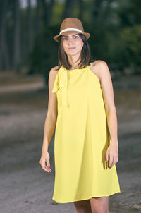 Portrait of woman standing against trees on field