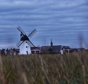 Traditional windmill on field against sky