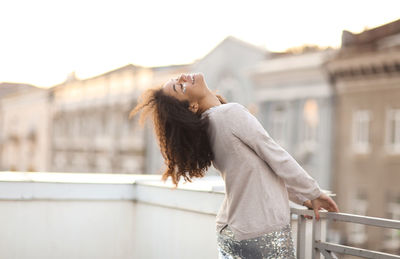 Side view of young woman looking away in city