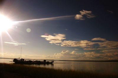 Sun shining through clouds over sea