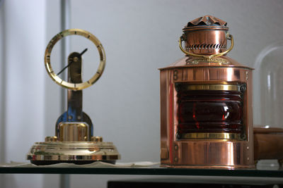 Close-up of clock and container on table at home