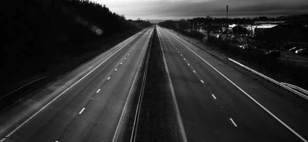 Railroad tracks by road against sky