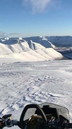 Cars on snowcapped mountains against sky