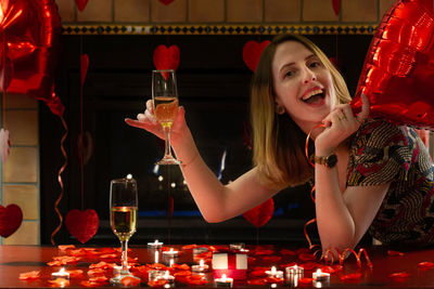 Portrait of a smiling young woman drinking glass
