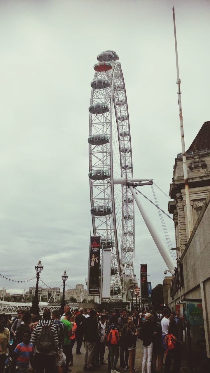 PEOPLE ON AMUSEMENT PARK RIDE AGAINST SKY