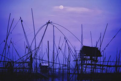 Low angle view of silhouette cranes against sky at sunset