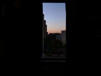 Silhouette buildings against sky at dusk