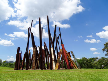 Wooden posts on field against sky
