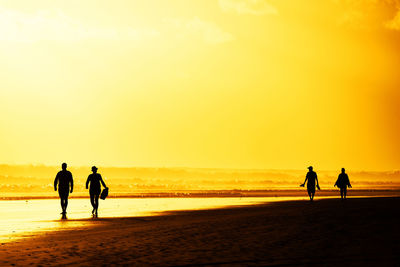 Tourists visiting beach against sky