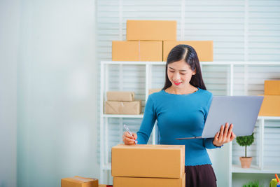 Young woman using mobile phone in box