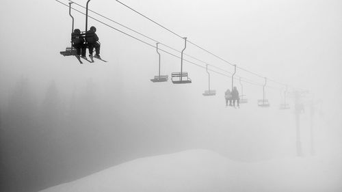 Low-angle view of young couple on ski lift