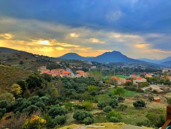 Scenic view of town by mountains against sky