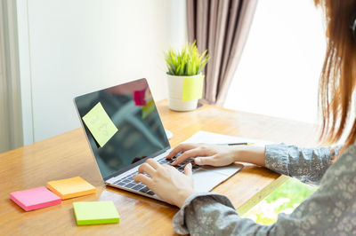 Woman using mobile phone while sitting on table