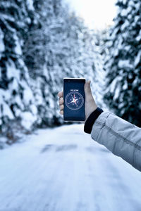 Close-up of person using smart phone on snow