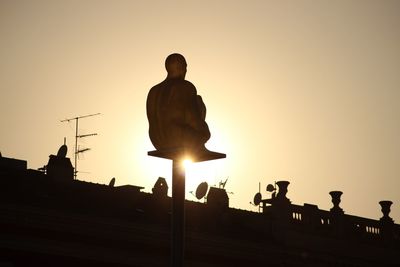 Silhouette statue against sky during sunset